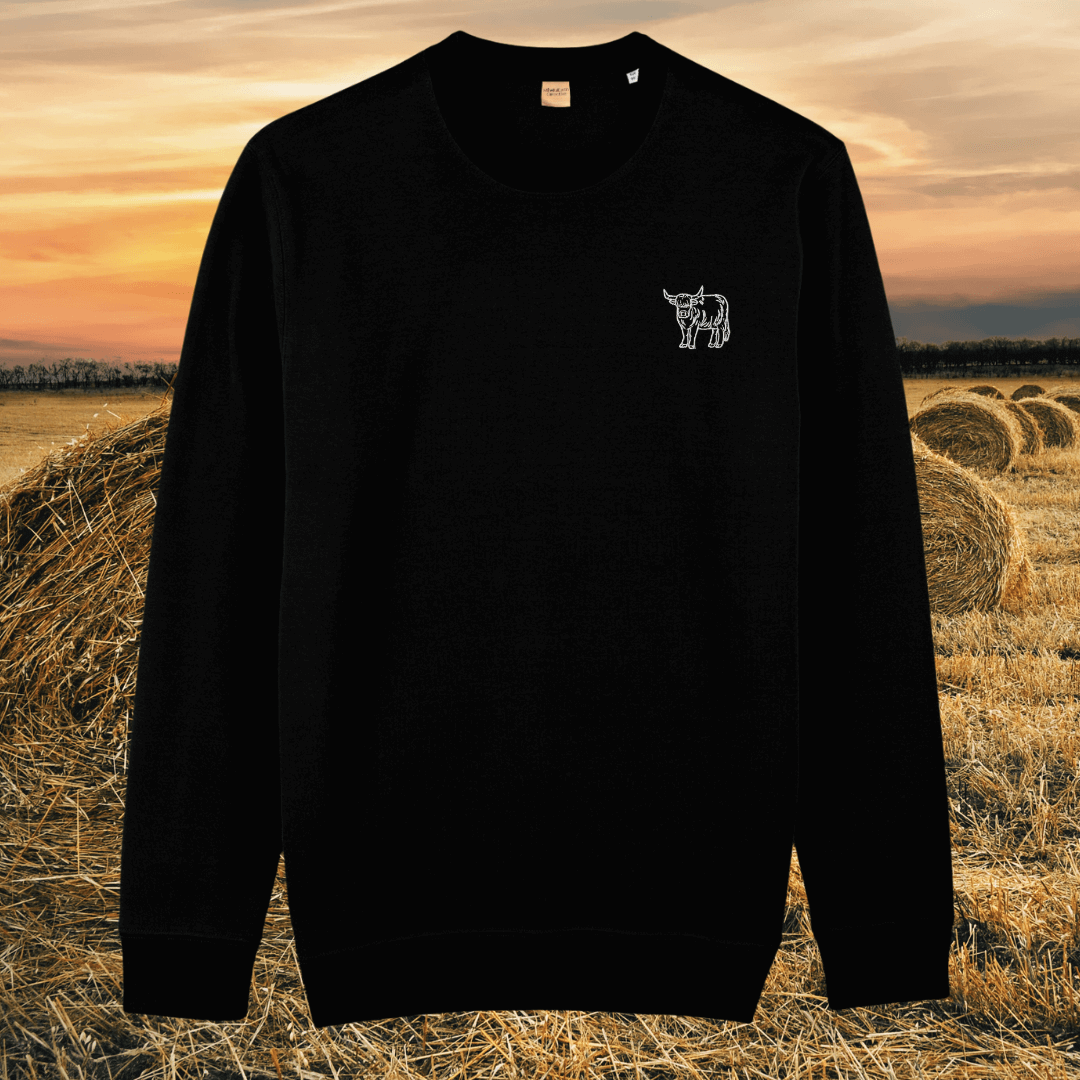 Front view of the Highland Cow Black organic cotton sweater featuring the “Live Like Someone Left the Gate Open” design by Mindful Earth.