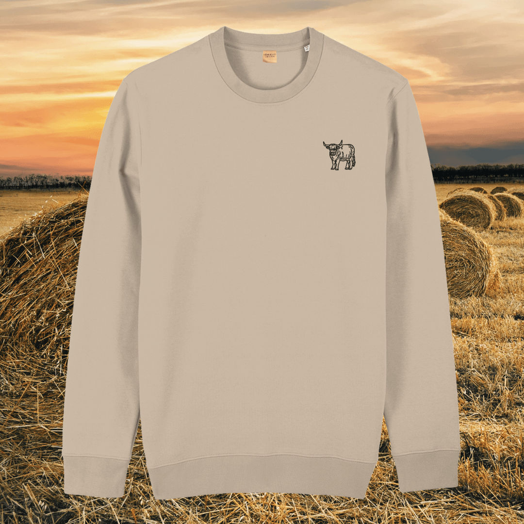 Front view of the Highland Cow Desert Dust organic cotton sweater featuring the “Live Like Someone Left the Gate Open” design by Mindful Earth.