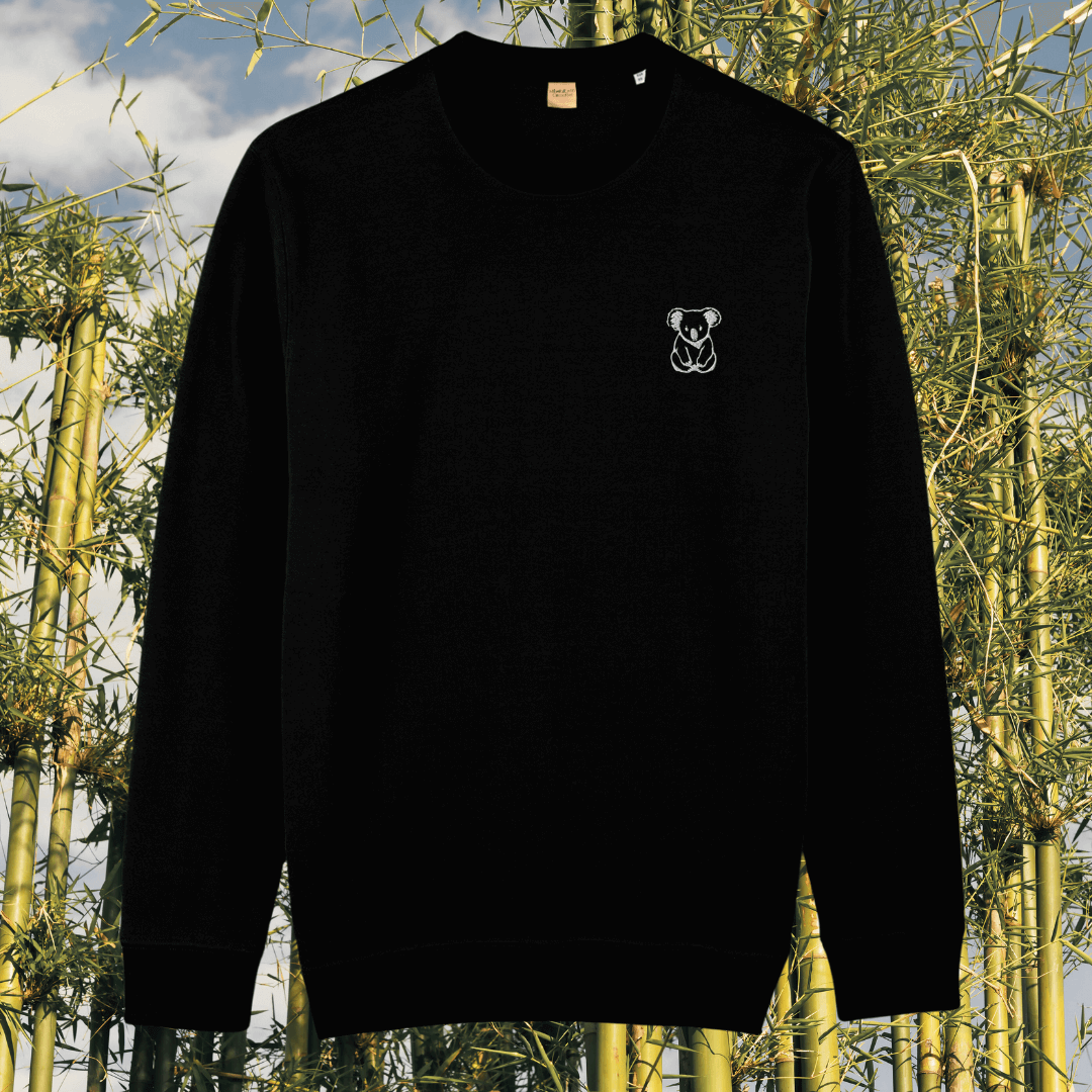 Front view of the Koala Black organic cotton sweater featuring the “Create Your Happy Place” design by Mindful Earth.