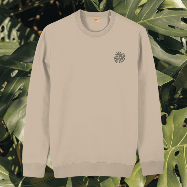 Front view of the Monstera Desert Dust organic cotton sweater featuring the “Life’s a Climb but the View is Great” design by Mindful Earth.
