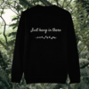 Back of the black organic cotton sweater featuring sloth illustration and the phrase “Just Hang In There” – Mindful Earth UK sustainable fashion